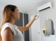 Kobieta włącza klimatyzację w domu